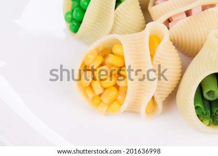 Pasta shells stuffed with vegetables and sausage. Whole background.