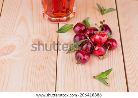 cherry juice with cherries isolated on a wooden background