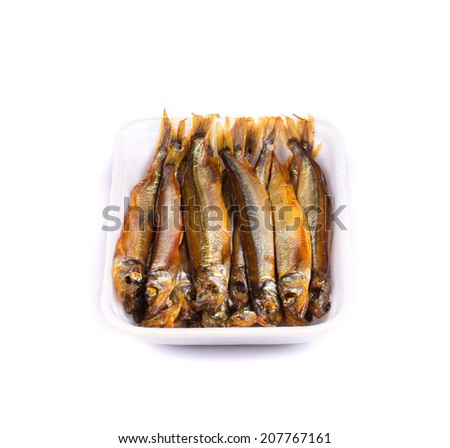 Smoke-dried anchovies in plate close up. Isolated on a white background.
