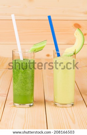 Smoothies of cucumbers and melon. Located on wooden background.