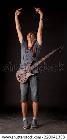 Bass guitarist. Located on the black background.