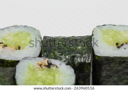Traditional japanese vegetarian sushi roll with cucumber and sesame. As a whole background.