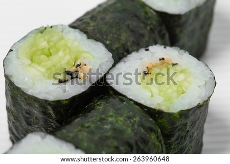 Traditional japanese vegetarian sushi roll with cucumber and sesame. As a whole background.