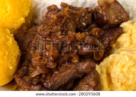 Roasted pork meat with scrambled eggs and maize porridge. Macro. Photo can be used as a whole background.