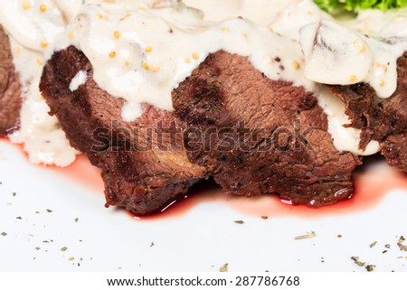 Sliced beef steak covered with delicious sauce. Macro. Photo can be used as a whole background.
