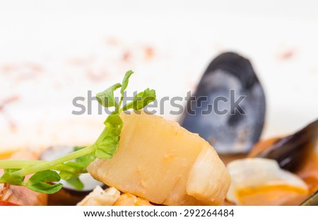 Closeup of celery root in tomato seafood soup. Macro. Photo can be used as a whole background.
