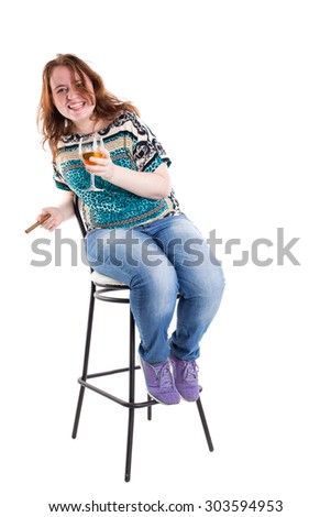 Smiling redhead plus size wreckled model sitting on the bar chair with glass of whiskey and cigar. Studio shot. Isolated on a white background.