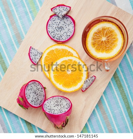 Dragon fruit and oranges with tea on dessert