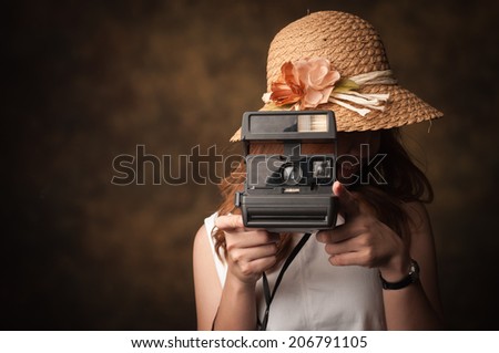 Young woman with her camera on a old background