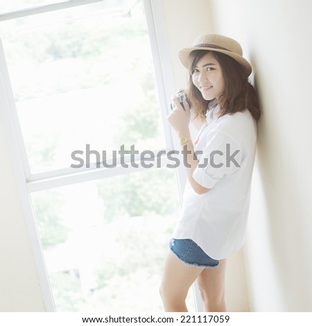 Woman photographer holding film camera near the window