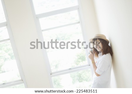 Woman photographer holding film camera near the window