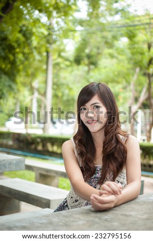 Woman sitting on stone chair in the park