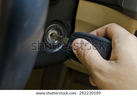 Hand holding car key for starting the car.
