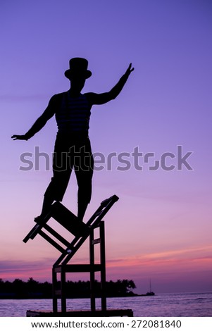 A street performer balancing on chairs during the Sunset Celebration Mallory Square, Key West, Florida