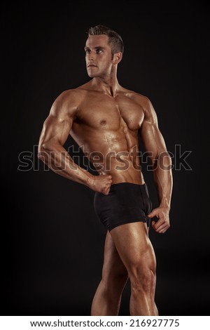 Strong Athletic Man Fitness Model Torso showing big muscles over black background