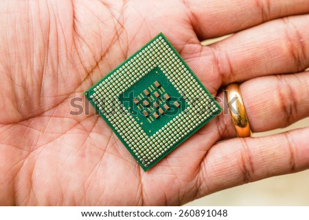 Close-up of a computer processor microchip between the fingers in hand