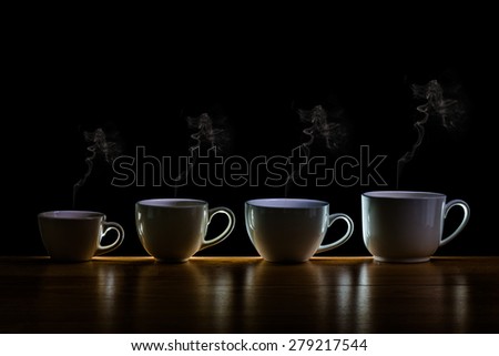 Variety of cups of coffee with smoke on table and black background,This photo is available without smoke