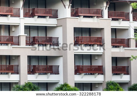 Pattern of hotel room balconies in modern building with one patio door open