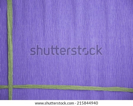 A blue crepe paper background with 2 green lines crossing at one corner