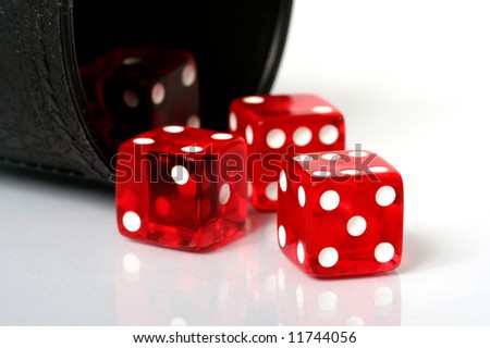 Red dice thrown from dice cup onto white background