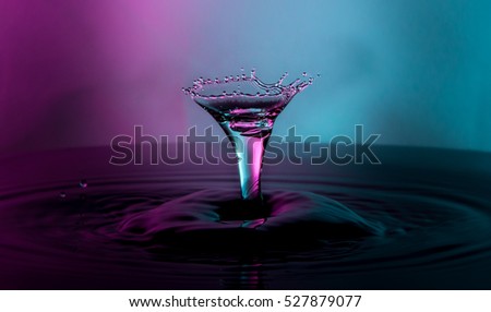 Water drop capture in the shape of a martini glass with purple and blue light