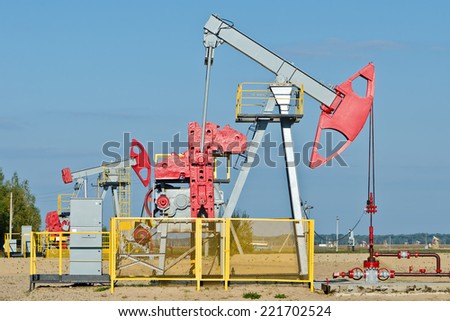 Oil and gas industry. Work of oil pump jack on a oil field. First pump in focus.