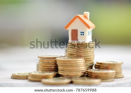 Mini house on stack of coins. Concept of Investment property.