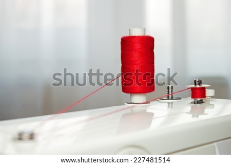 Sewing accessories. spool of thread and bobbin with red thread
