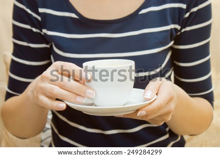 woman holds in hands white cup of coffee