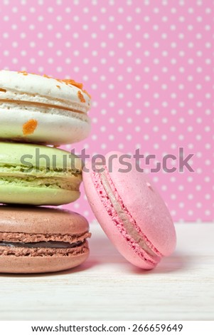 Traditional French dessert makarons on a colorful polka dots background