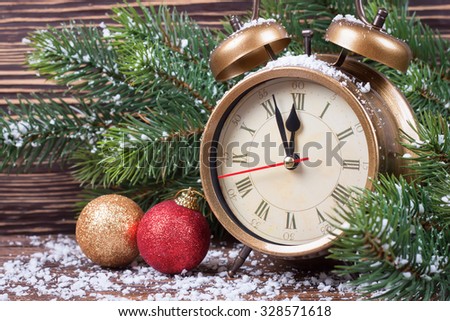 New Year clock and fir branches with Christmas balls and snowflakes