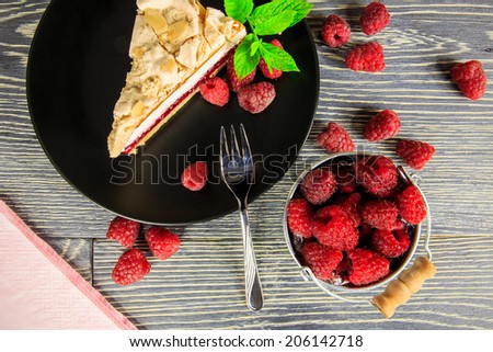 Raspberry cake with meringue top arranged on a wooden table