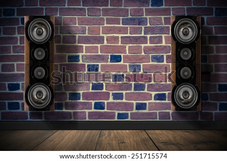 Brown music speakers on brick wall in dark room