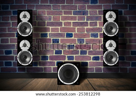 Black music speakers on brick wall and a subwoofer