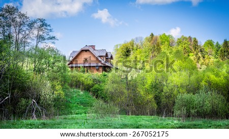 Beautiful wooden cottage on a hill somewhere in forest