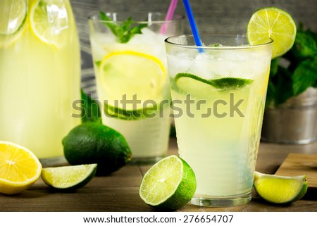 Refreshing lemonade drink and ripe fruits against wooden background