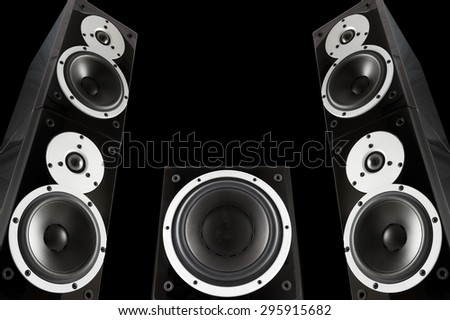Pair of black music speakers and subwoofer isolated on black background