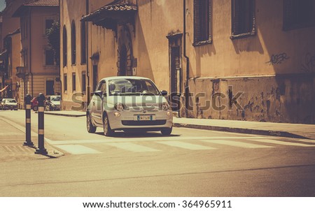 AREZZO, ITALY - JUNE 26, 2015: The newest version of Fiat 500, one of the most popular small city cars in Italy, on cross roads in tuscan Arezzo city, Italy