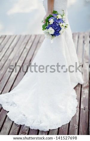 the bride with a bouquet from blue and white flowers; wedding concept