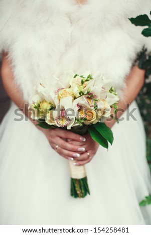 the bride holds a wedding bouquet from white orchids; wedding concept