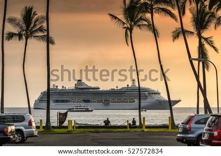 Cruise ship sailing, arriving to tropical island as seen from parking lot with palm trees at sunset