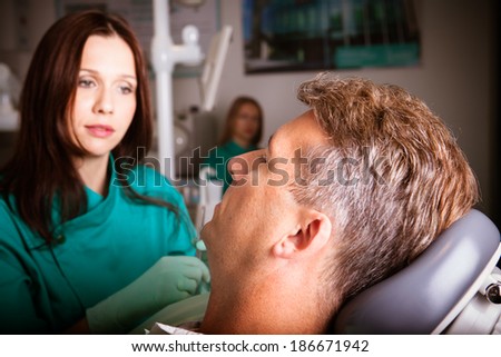 Middle aged patient in the dental clinic with the dentist doctor