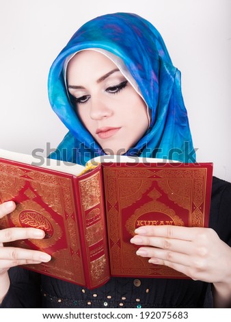 beautiful muslim woman wearing hijab and reading the Koran