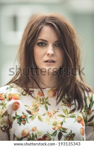 Brunette woman with messy hair outdoor portrait
