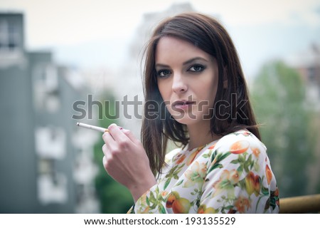 Beautiful brunette woman smoking addict smoking a cigarette