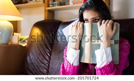 Funny looking brunette woman student trying to study in her room. Funny process of studying for exams