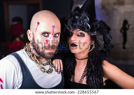 Guy dressed as pirate and woman dressed as witch, shot pirate Halloween costume, witch Halloween costume, Halloween party in costumes, friends at masquerade party having fun