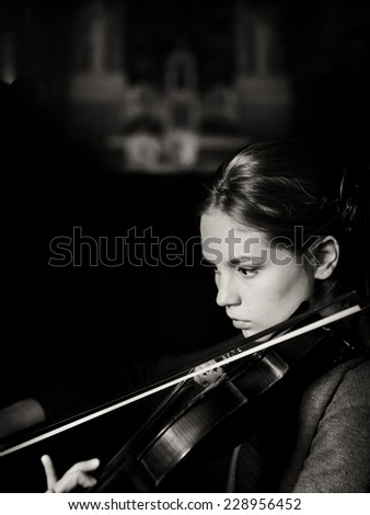 Beautiful young woman playing violin. Violinist woman playing violin live. Musician performer playing violin. Romantic surprise for your loved one. Violinist playing in church orchestra