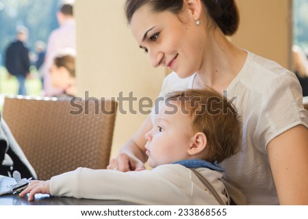 Young mother with her son in her arms.Portrait of a happy mother and baby laughing. Young mother holding her baby.Single working mom