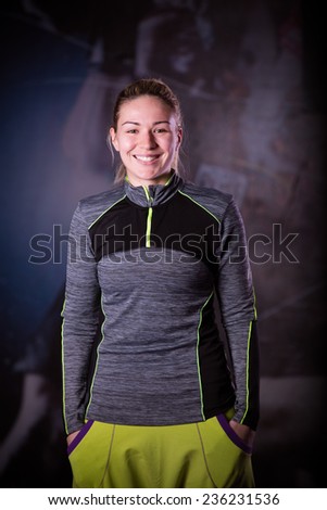 Fitness woman portrait at the gym. Smiling happy female fitness instructor looking at camera.